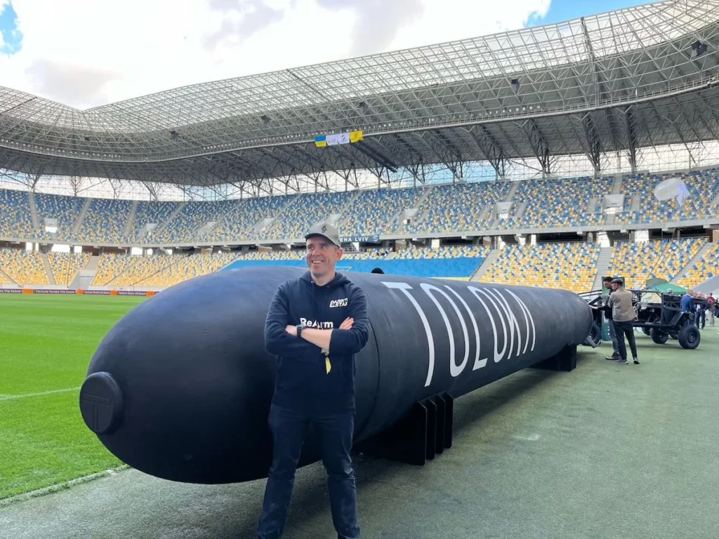 Людина на фоні підводного дрона на стадіоні